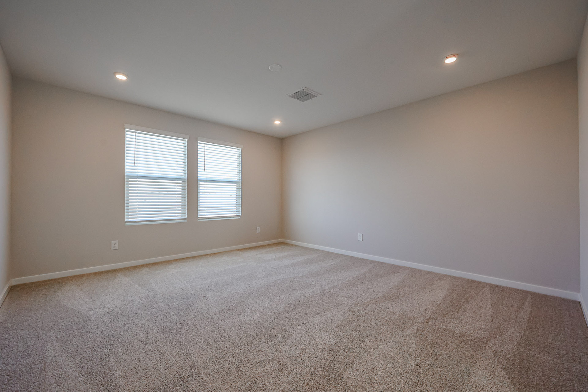 A room with a carpet and windows.
