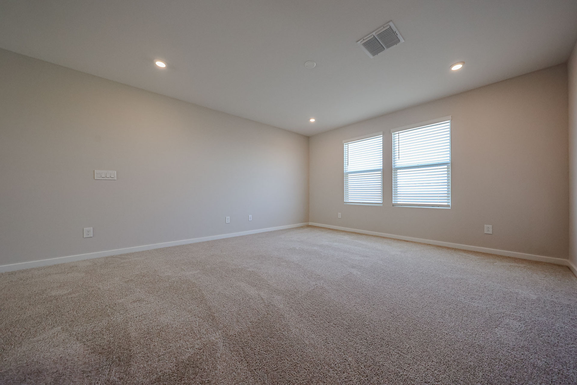 A room with a carpet and windows.