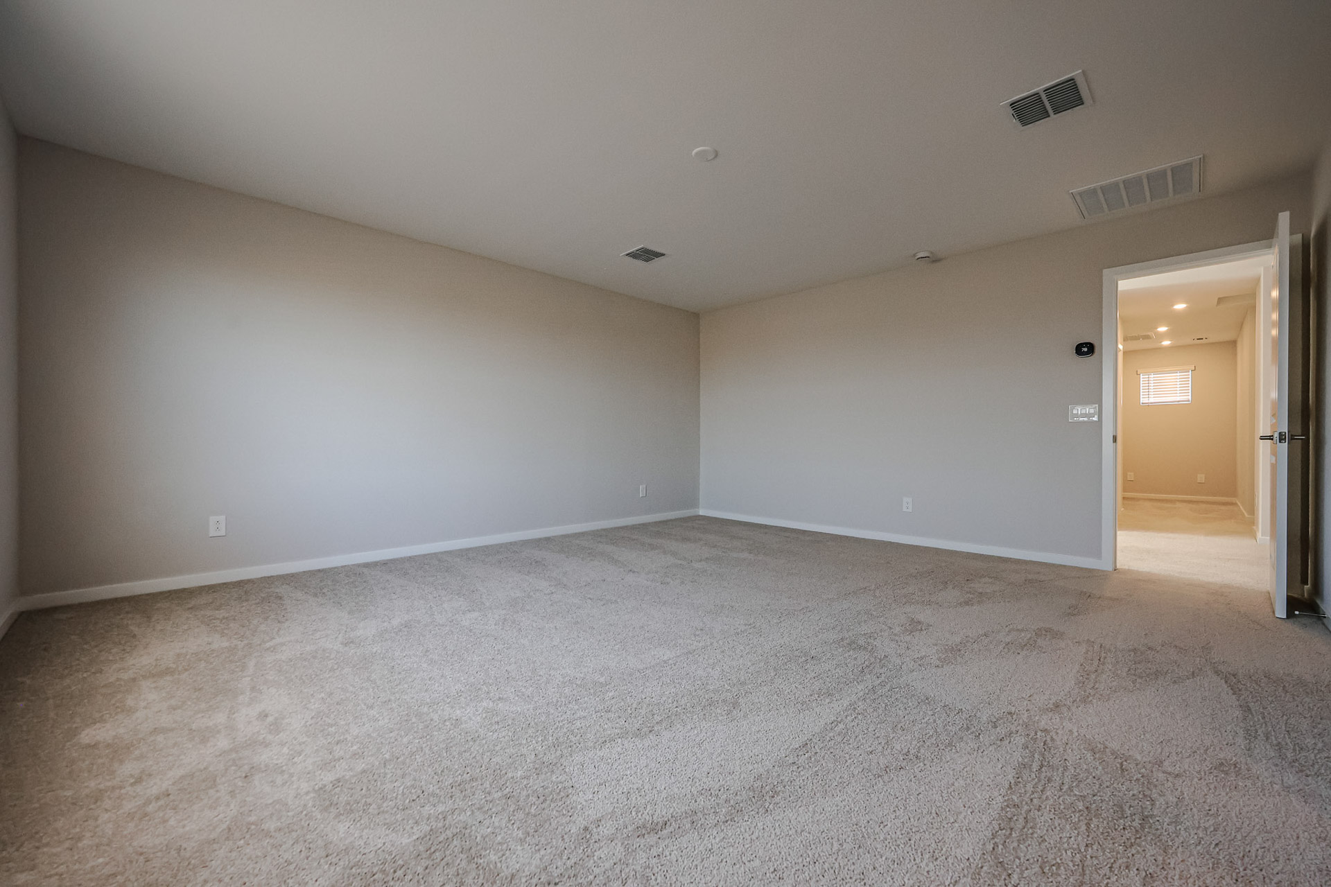 A room with a carpet and a door.