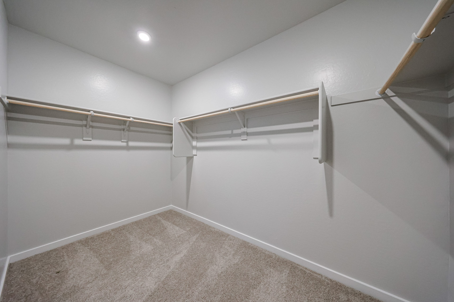 A white hallway with a metal railing.