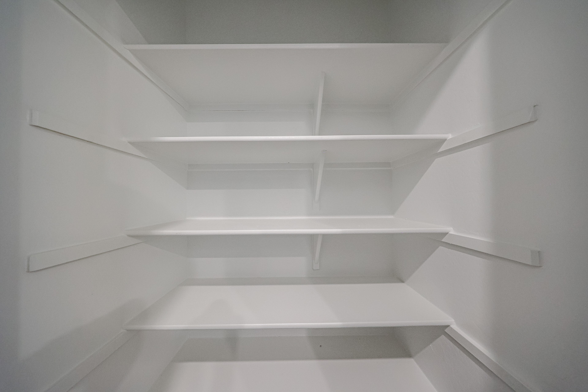 A white staircase with white walls.