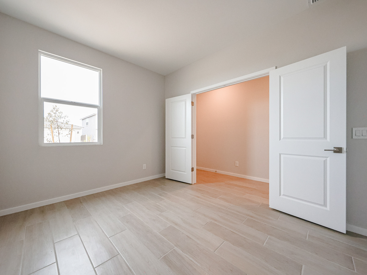 A room with white doors and a wood floor.