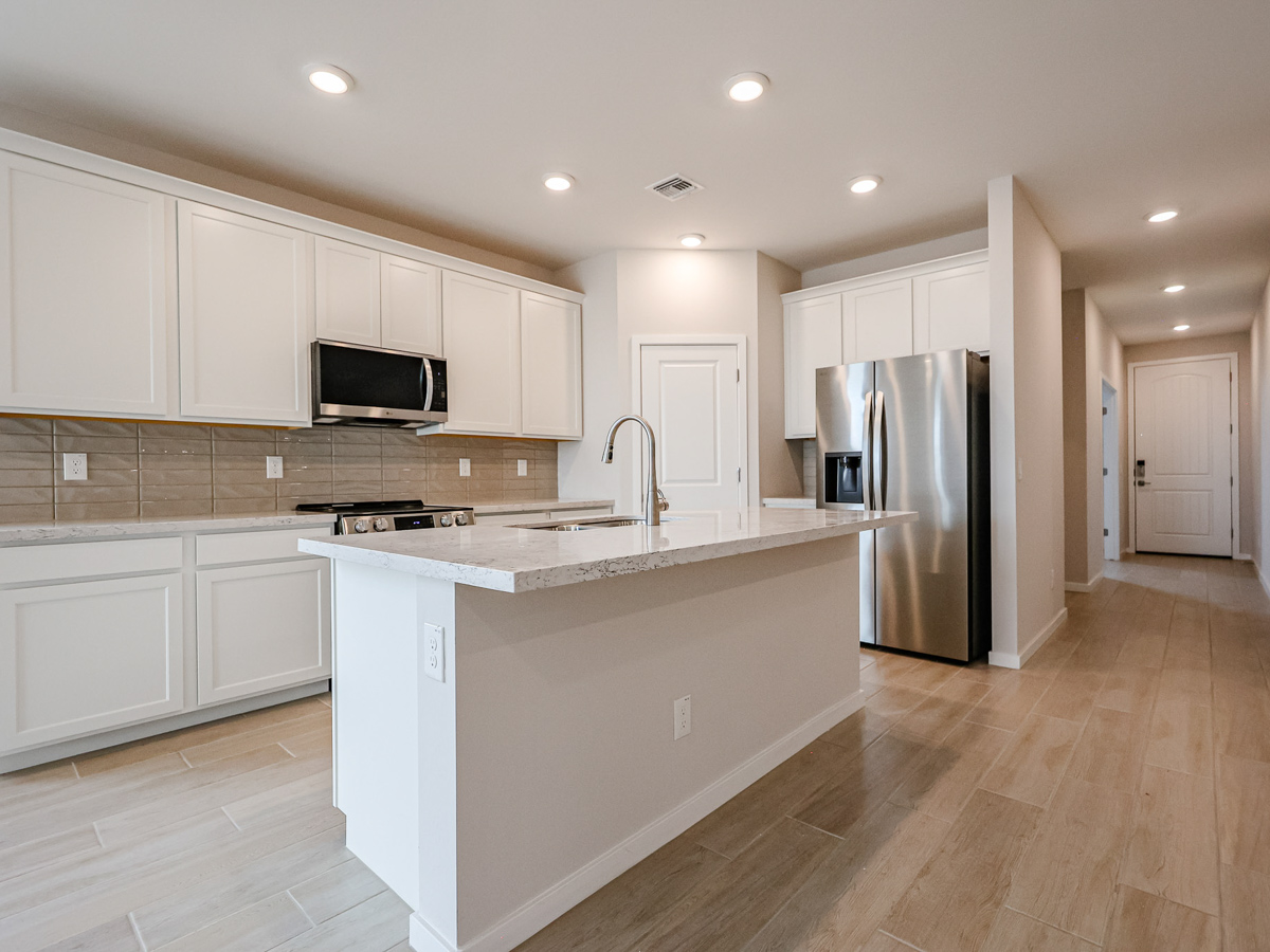 A kitchen with white cabinets.