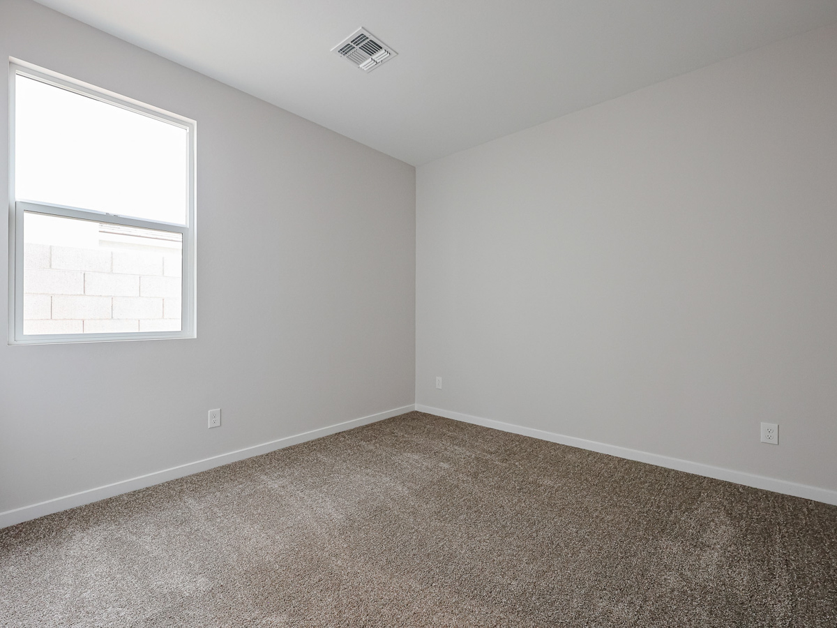 A room with a carpet and a window.
