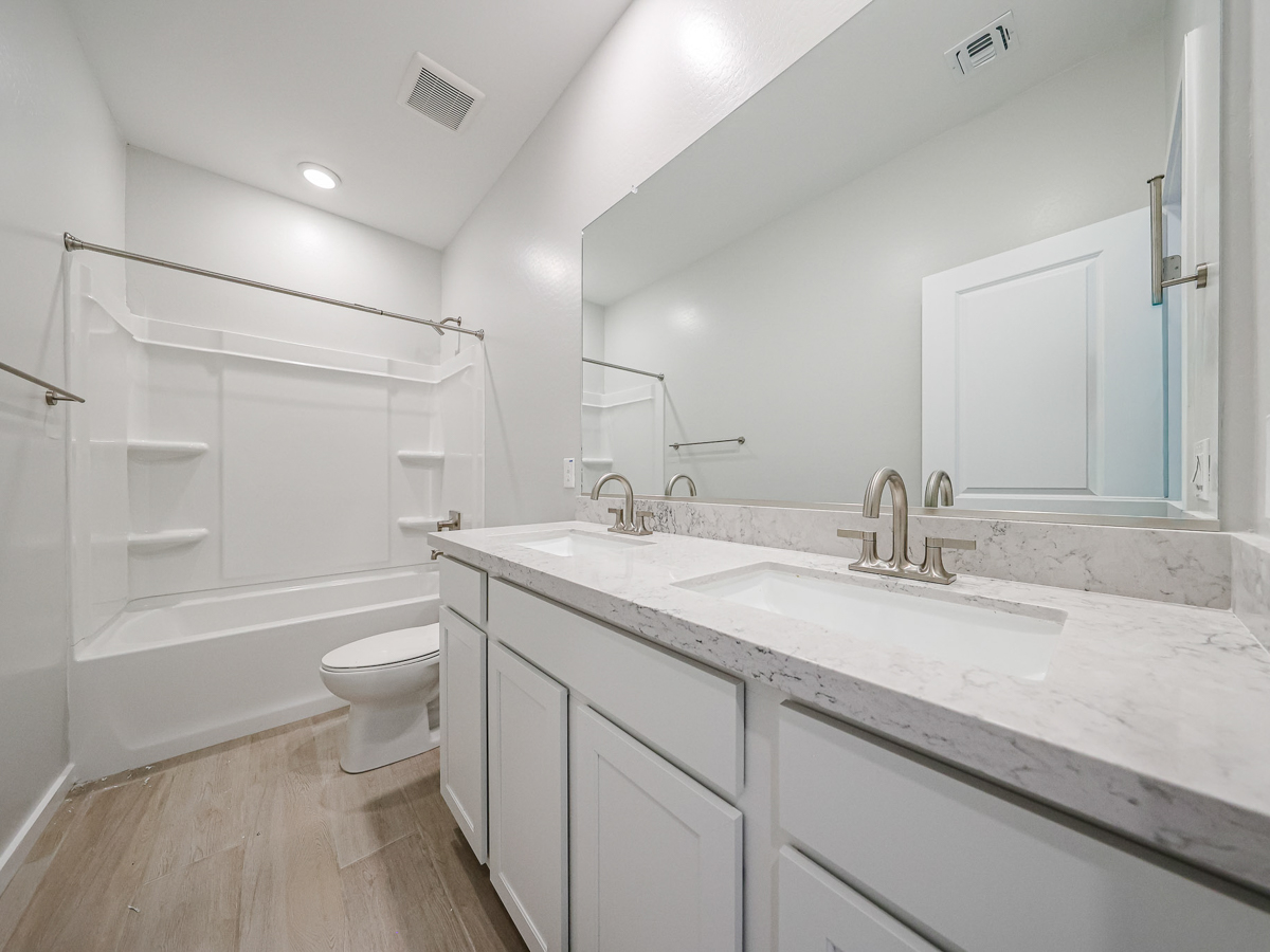 A bathroom with a tub sink and toilet.