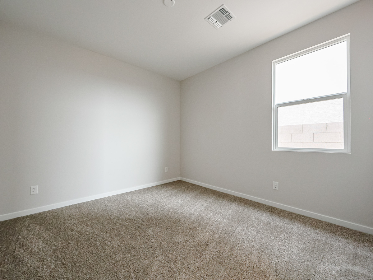 A room with a window and carpet.