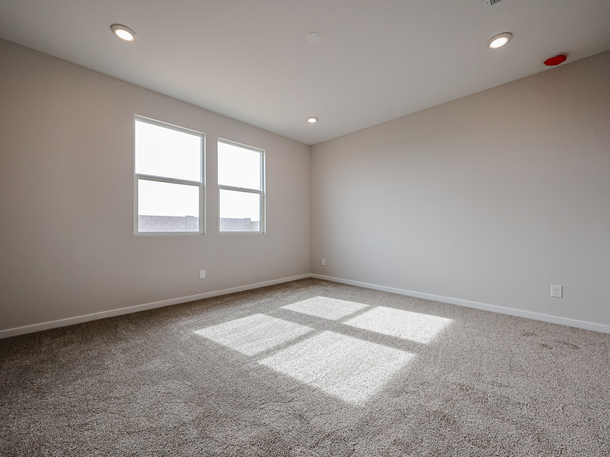 A room with a carpet and a window.