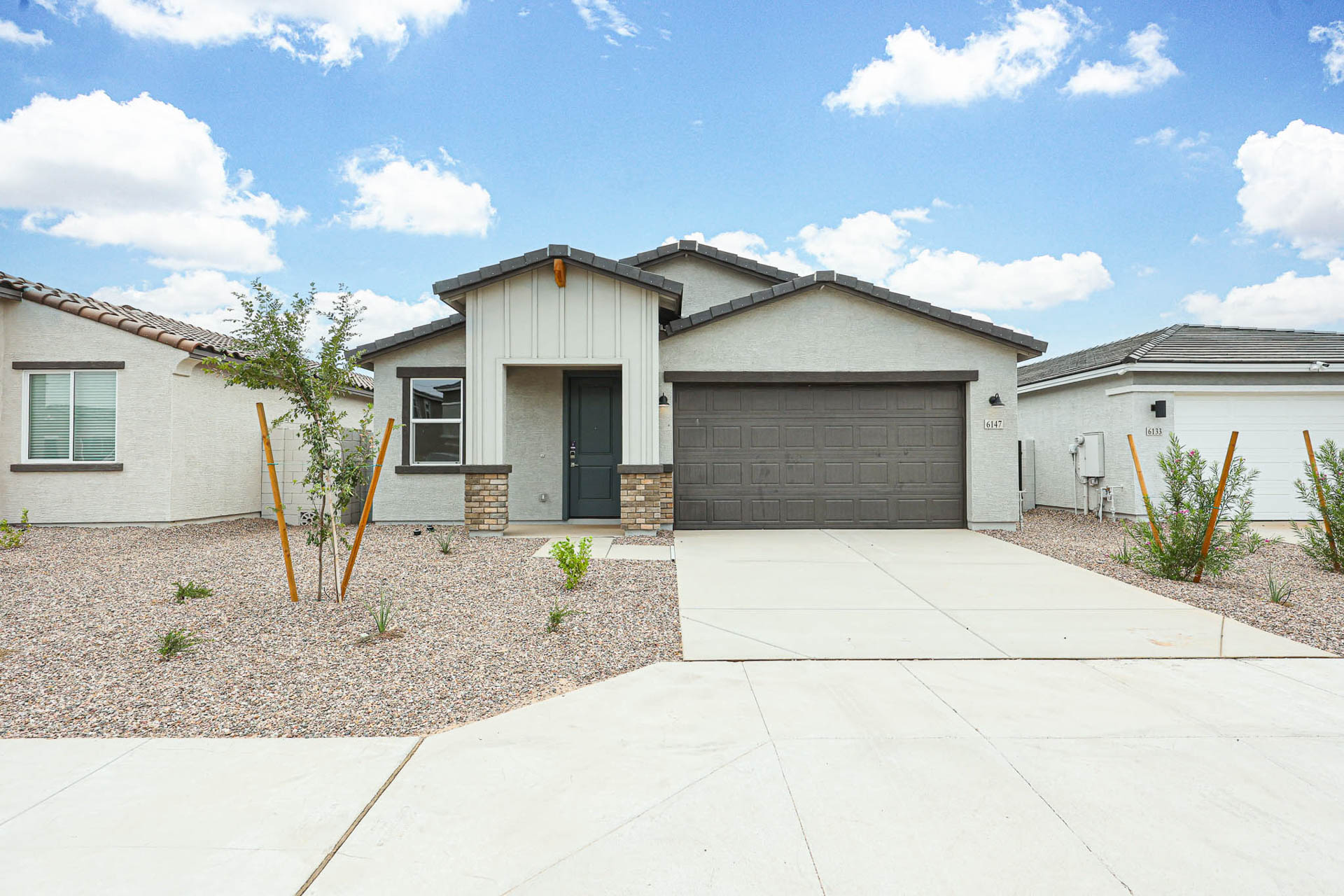 A house with garages and a tree in the front.