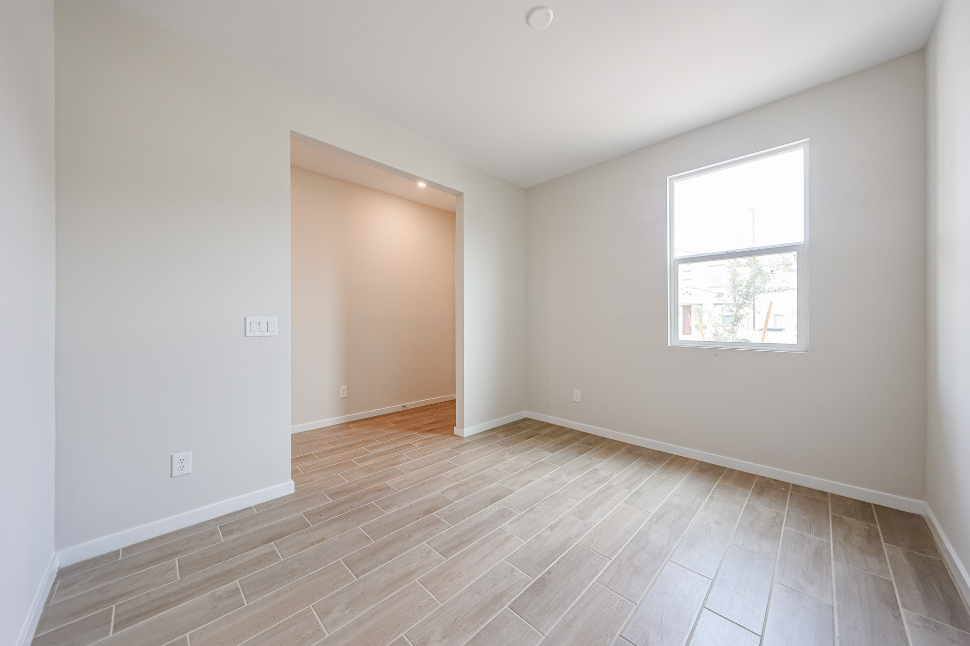 A room with a wood floor and a window.