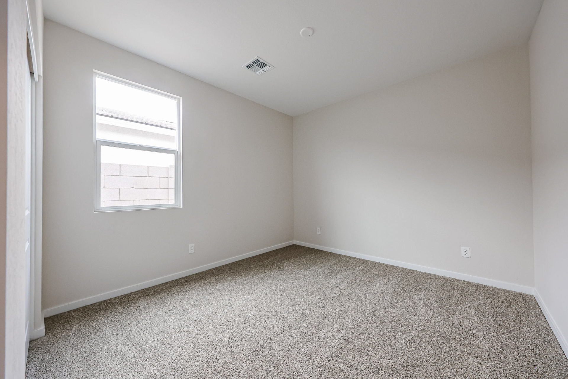 A room with a carpet and a window.