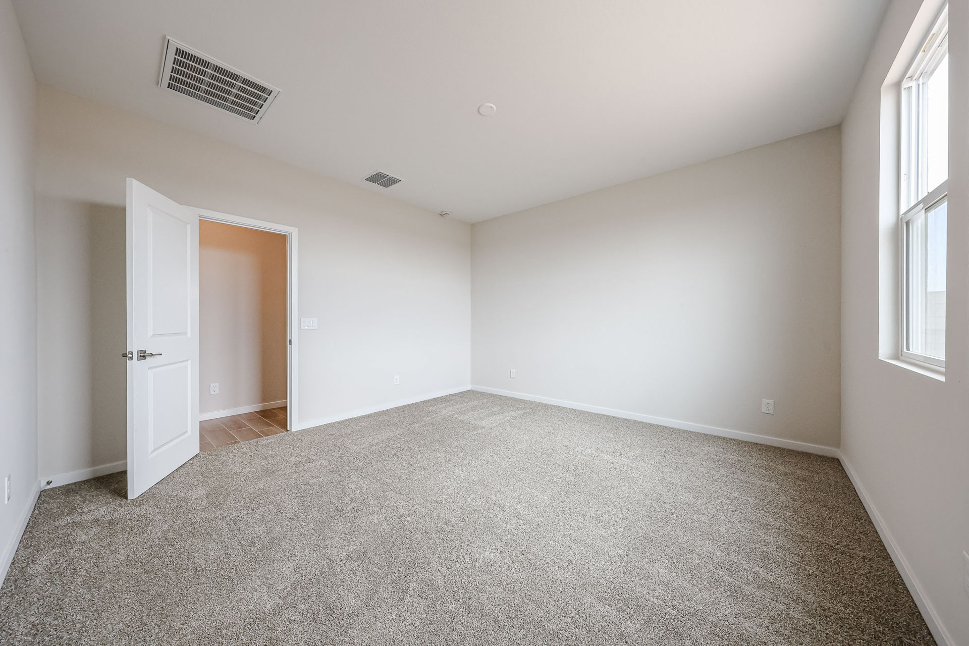 A room with a carpet and a door.