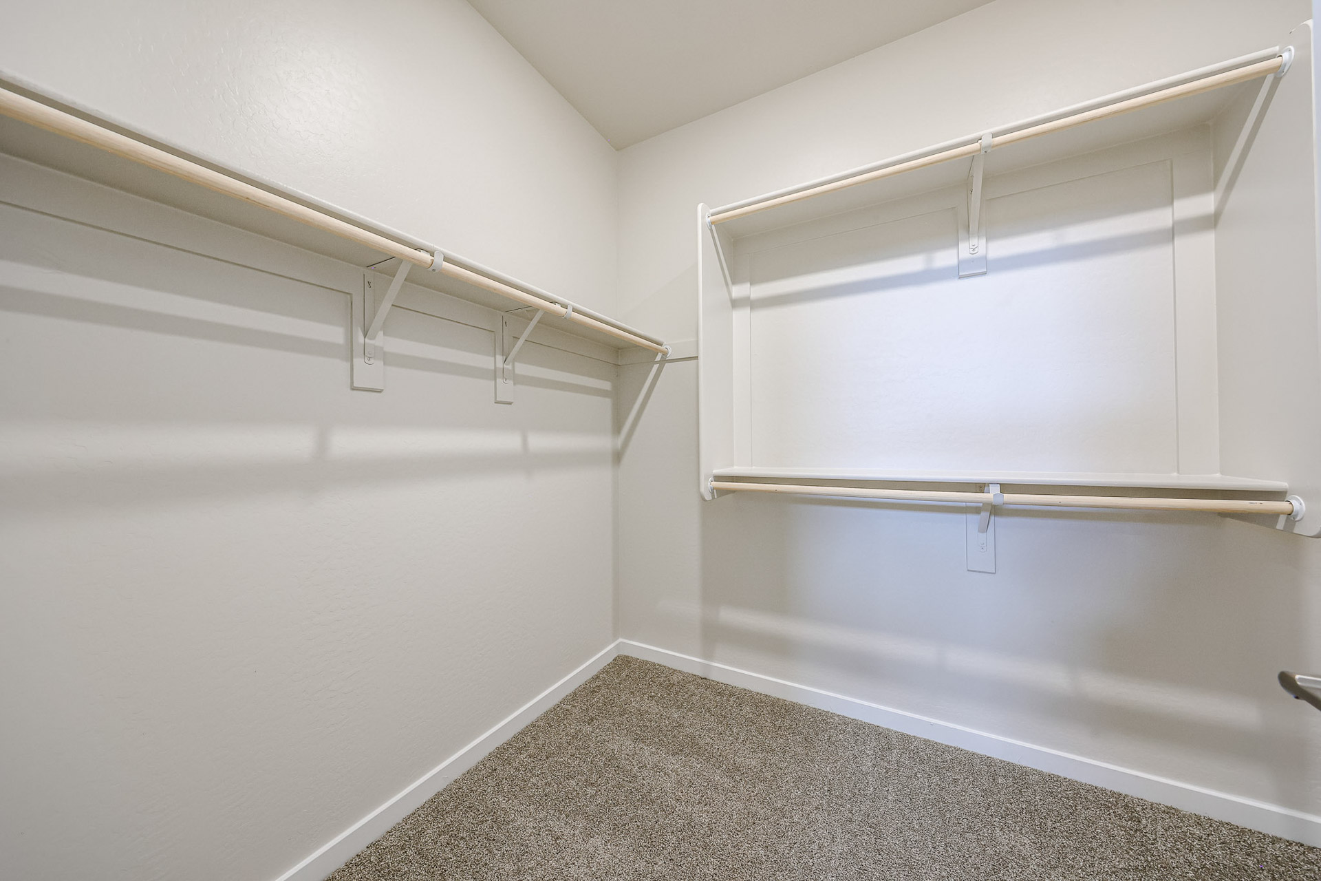 A white wall with a metal bar.