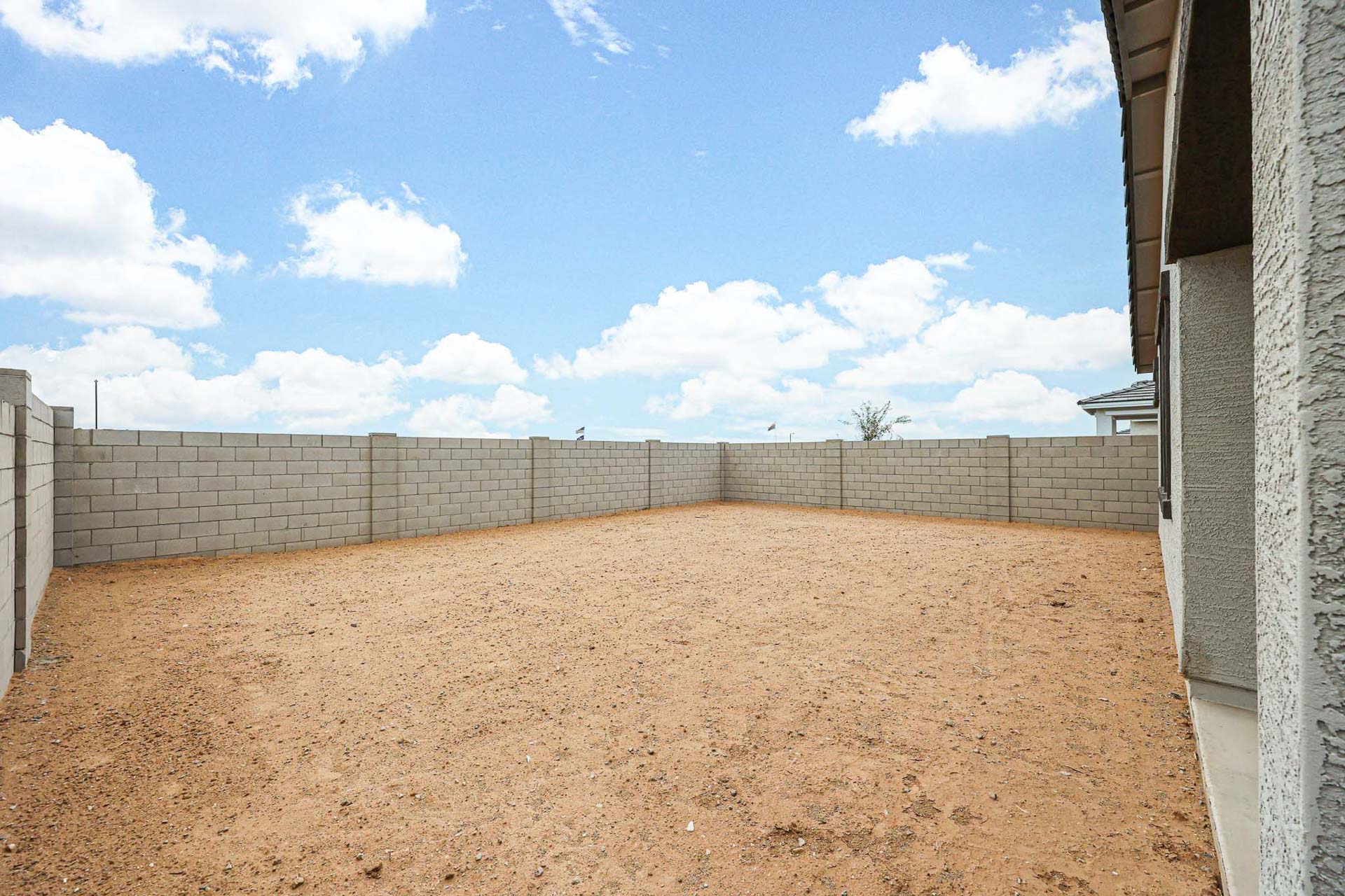A dirt field with a fence.
