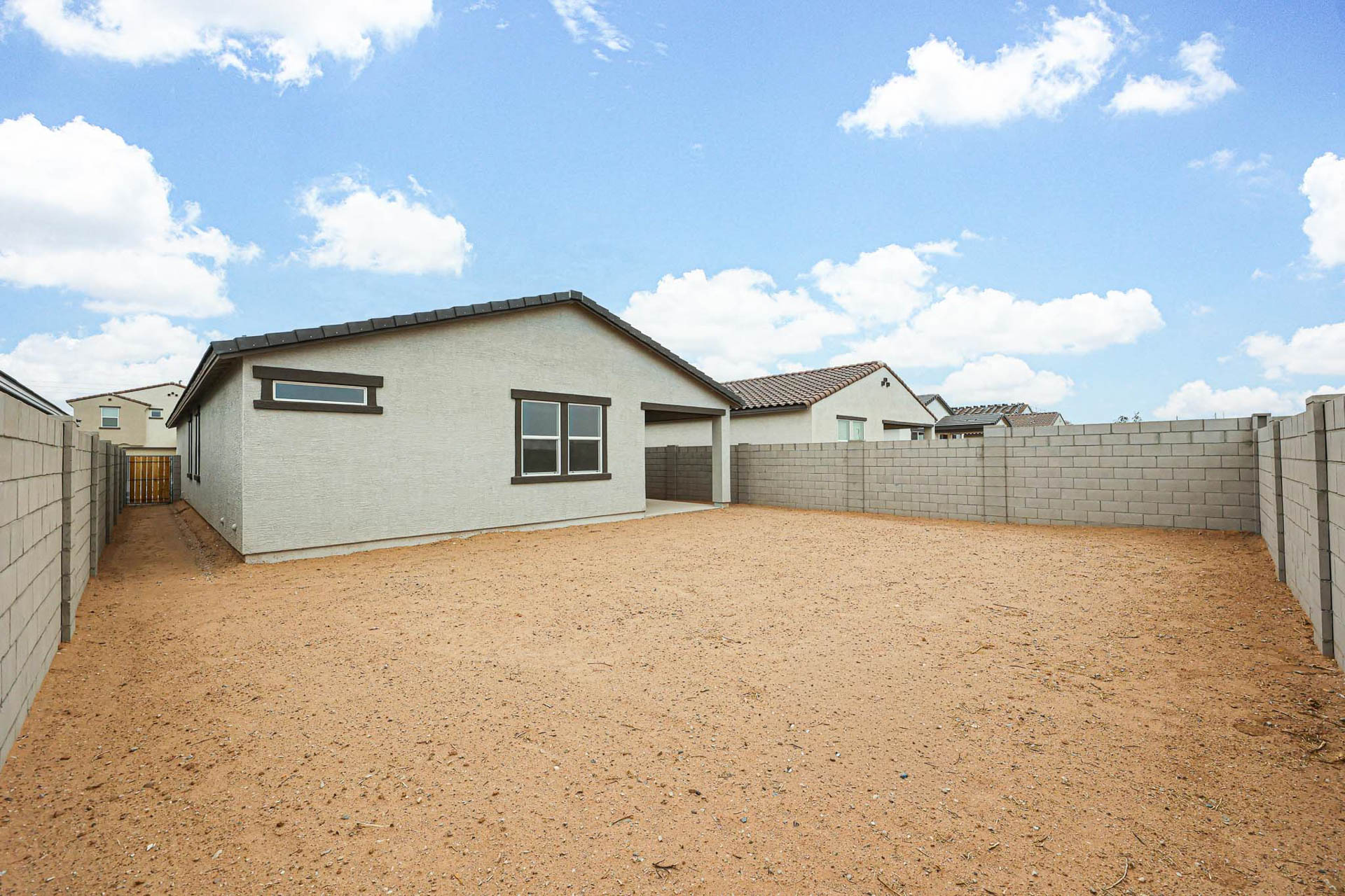 A dirt yard with a house.