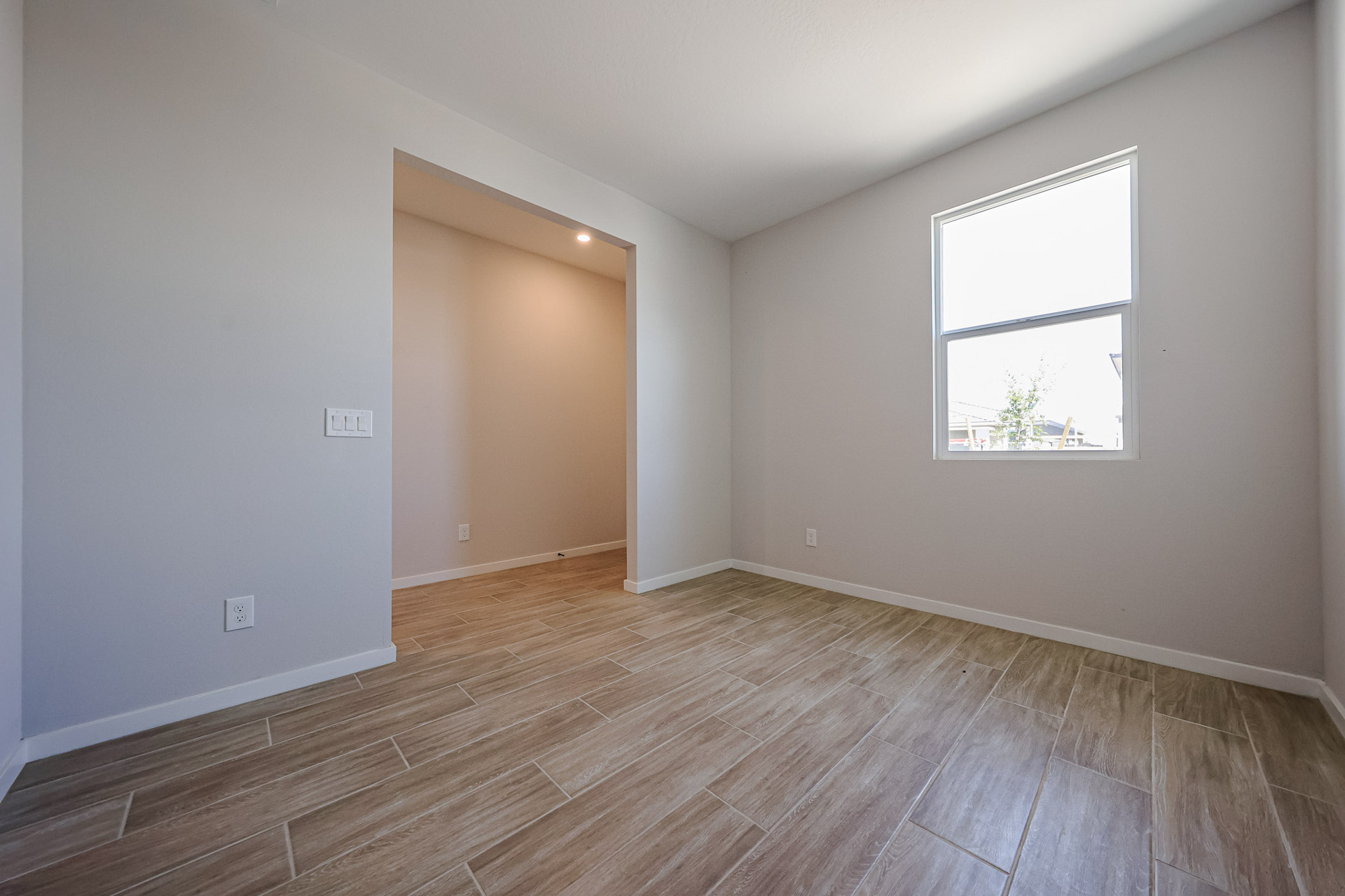 A room with a wood floor and a window.