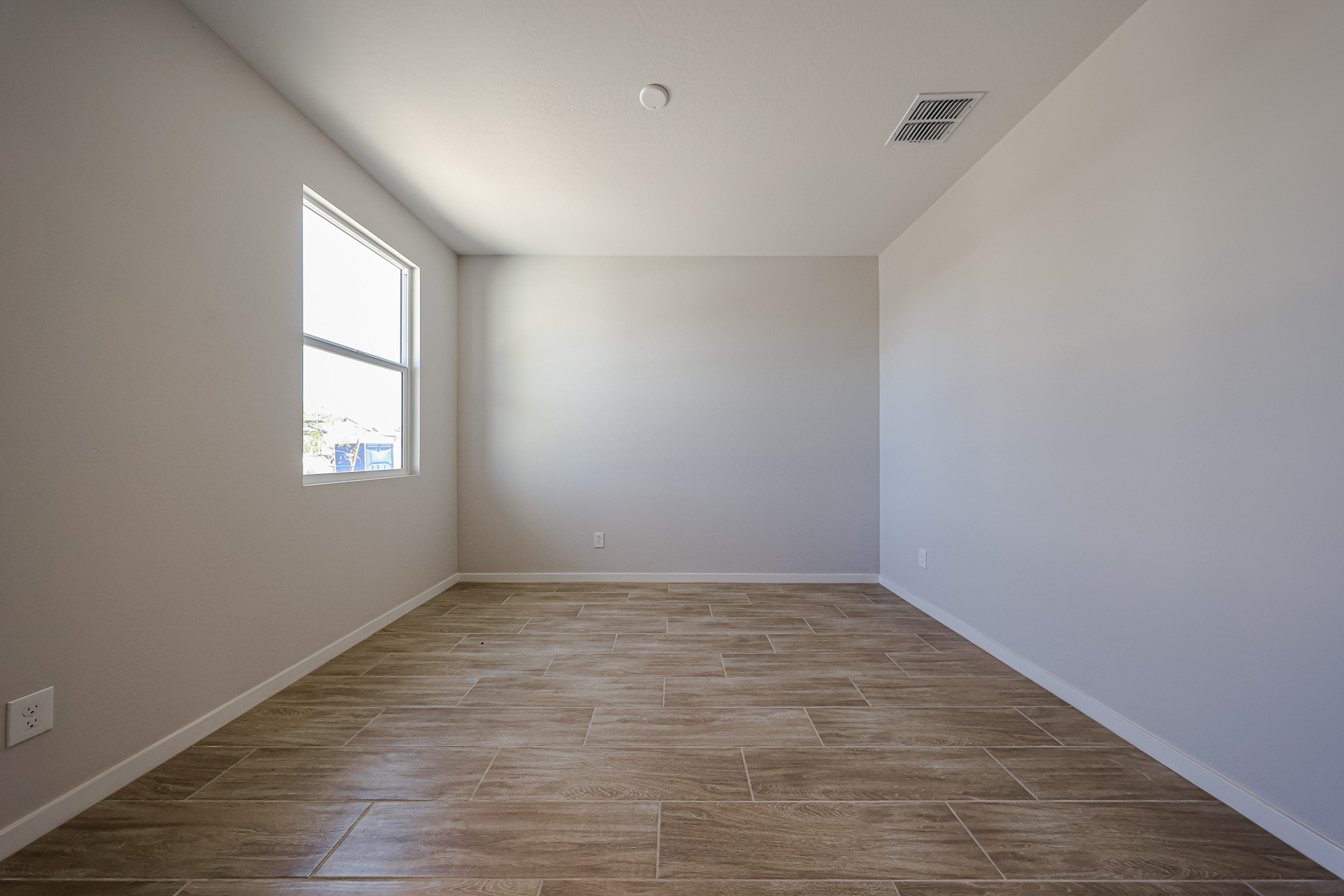 A room with a wood floor and a window.