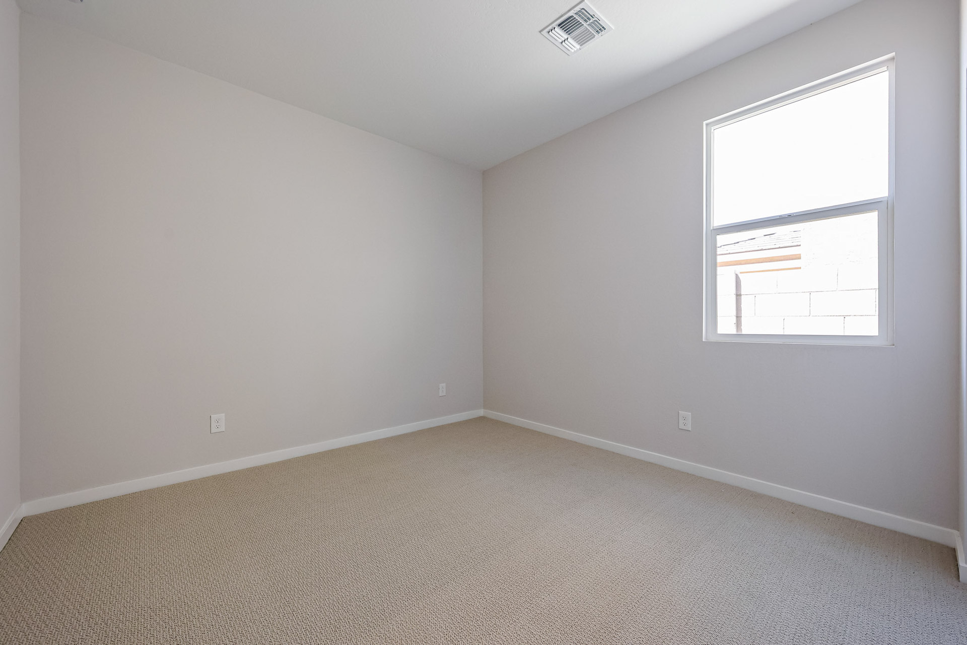 A room with a window and carpet.