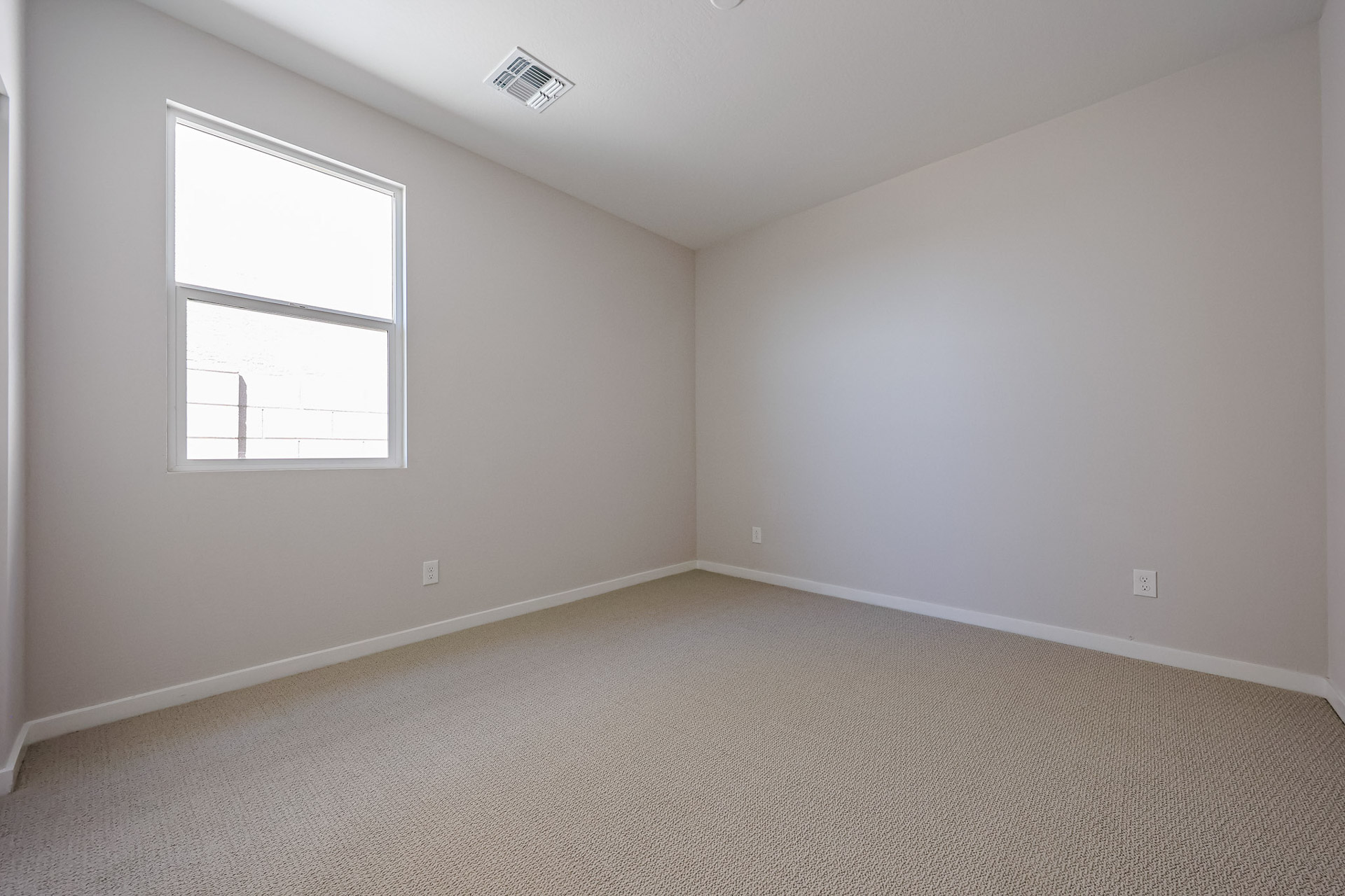A room with a window and carpet.