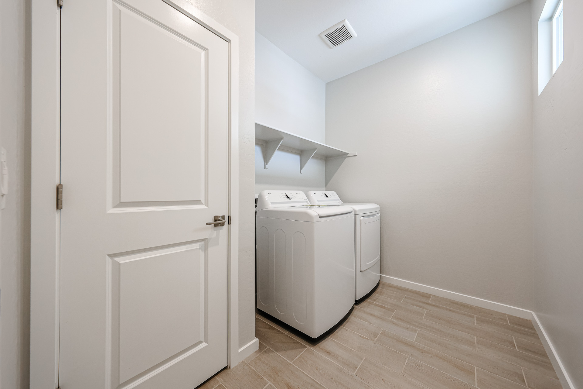 A white room with a white door and a white cabinet.