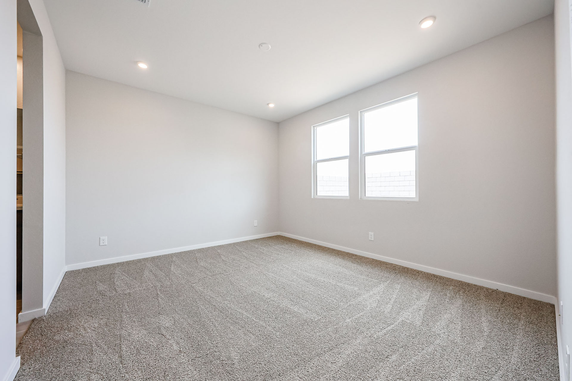 A room with a carpet and windows.