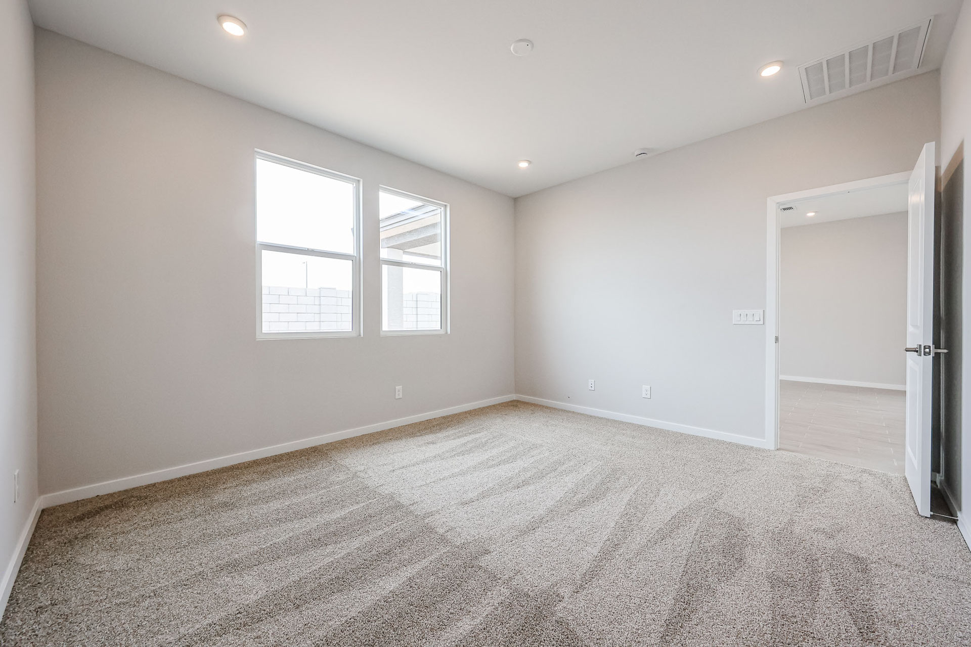 A room with a carpet and windows.