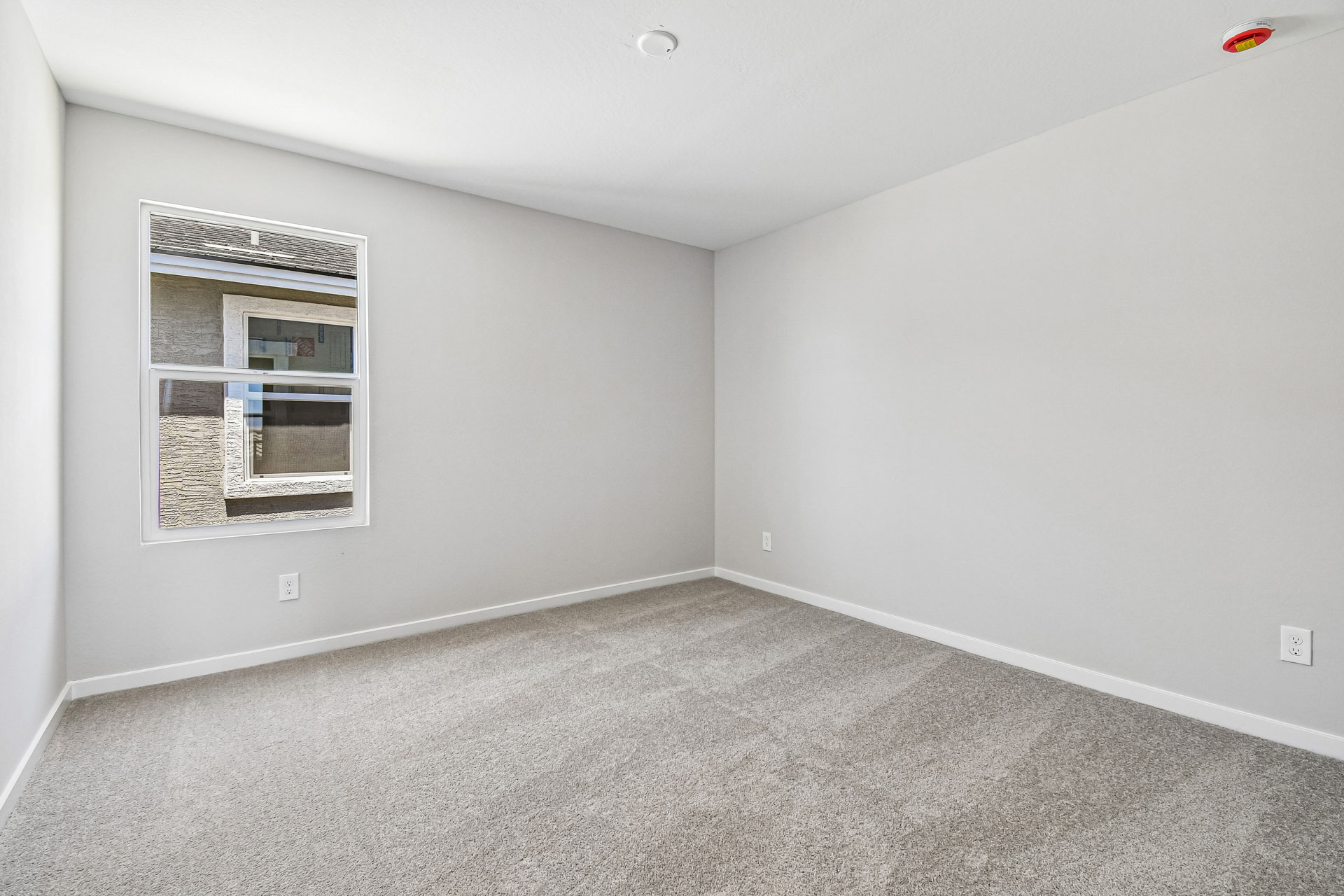 A room with a window and a carpet.