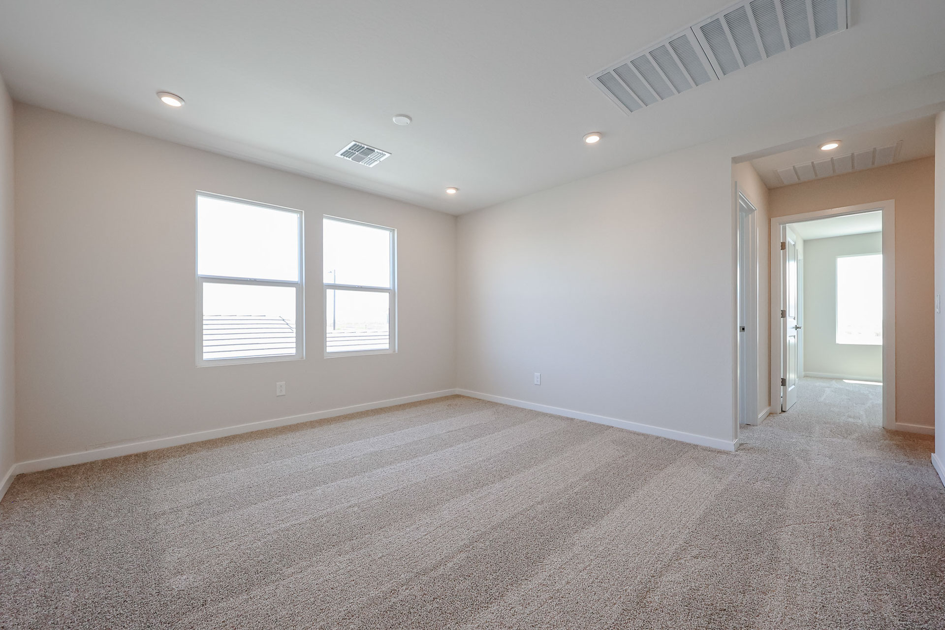 A room with a carpet and windows.