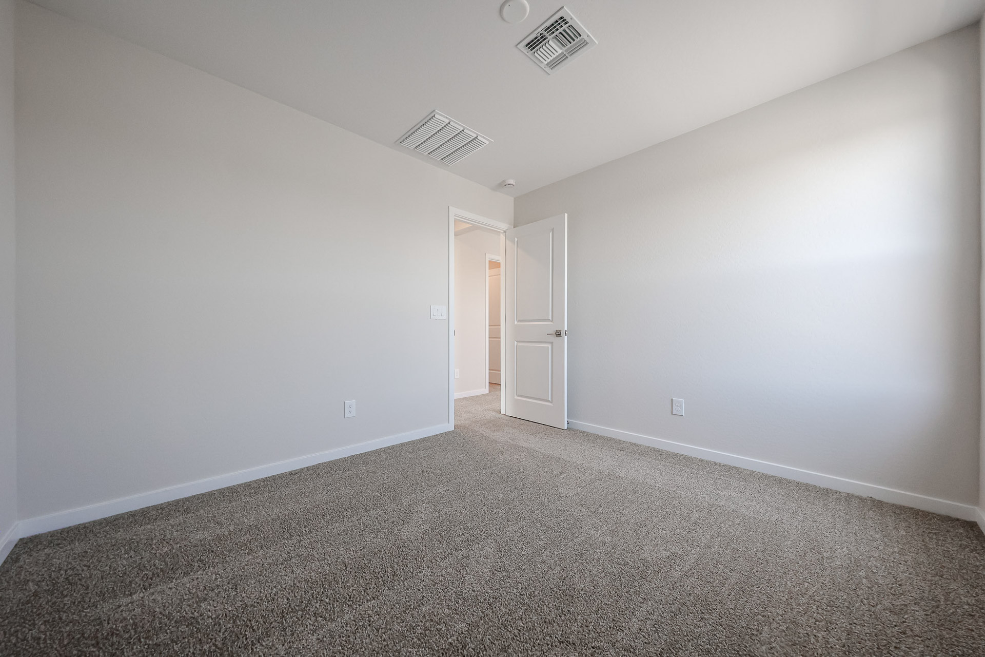 A room with a carpet and a door.