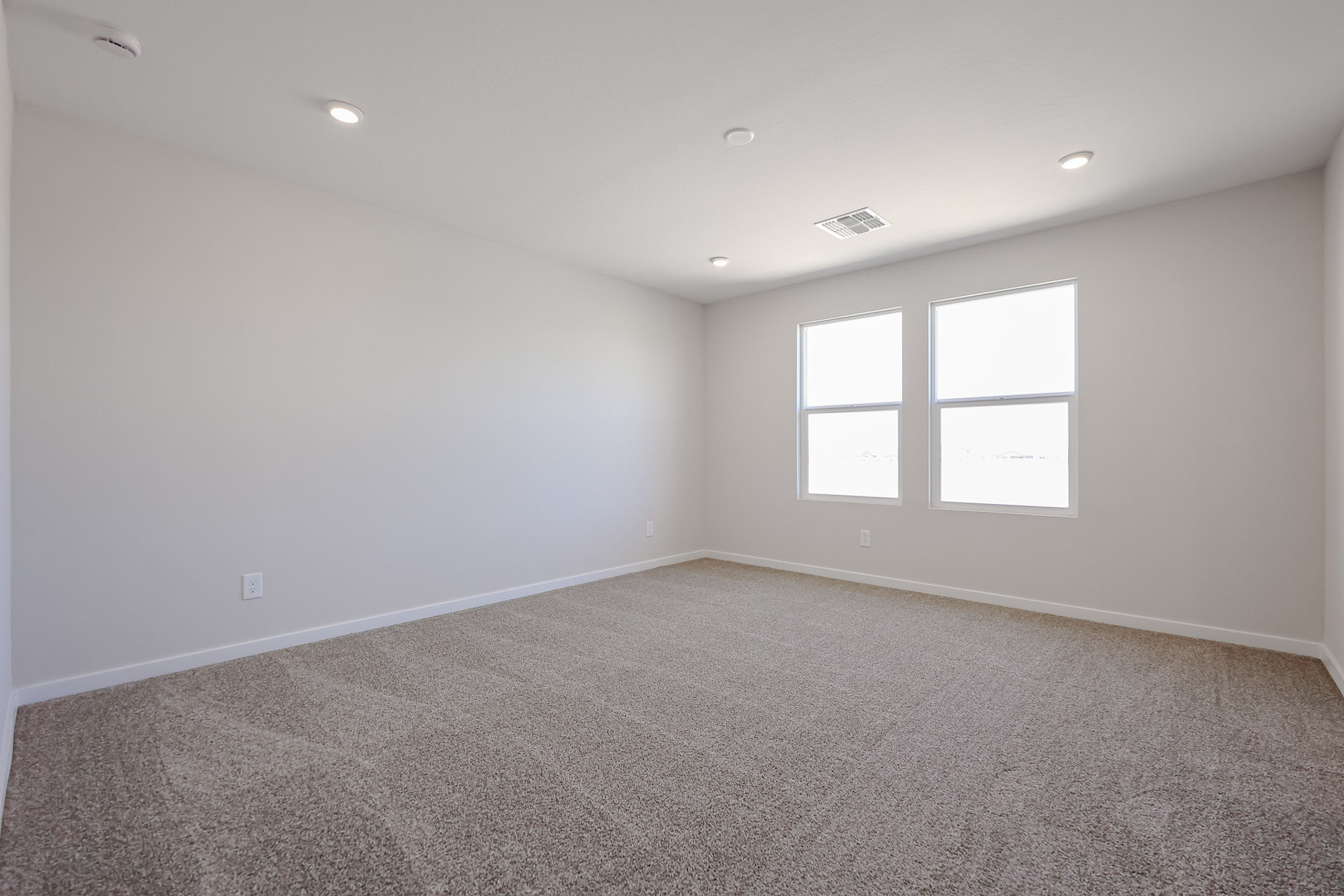 A room with a carpet and windows.