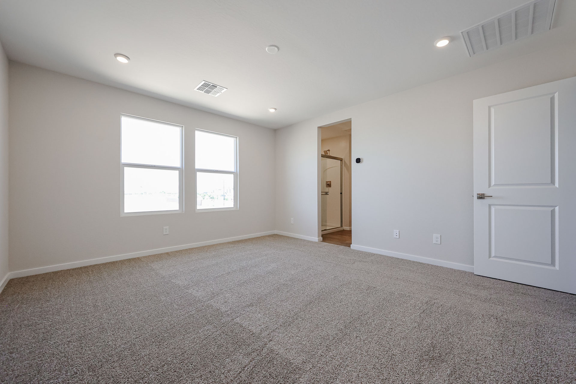 A room with a carpet and a door.