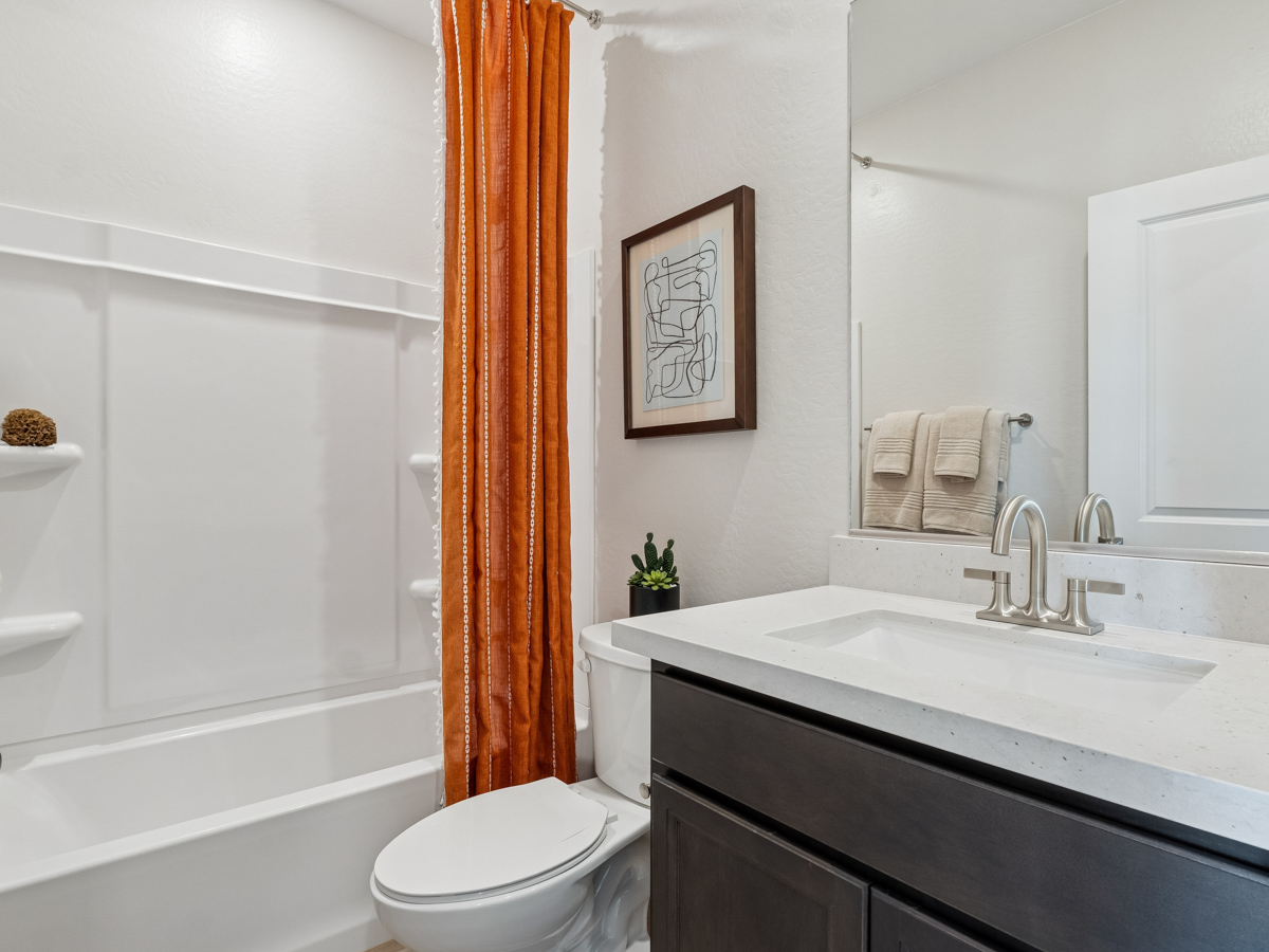 A bathroom with a tub sink and toilet.
