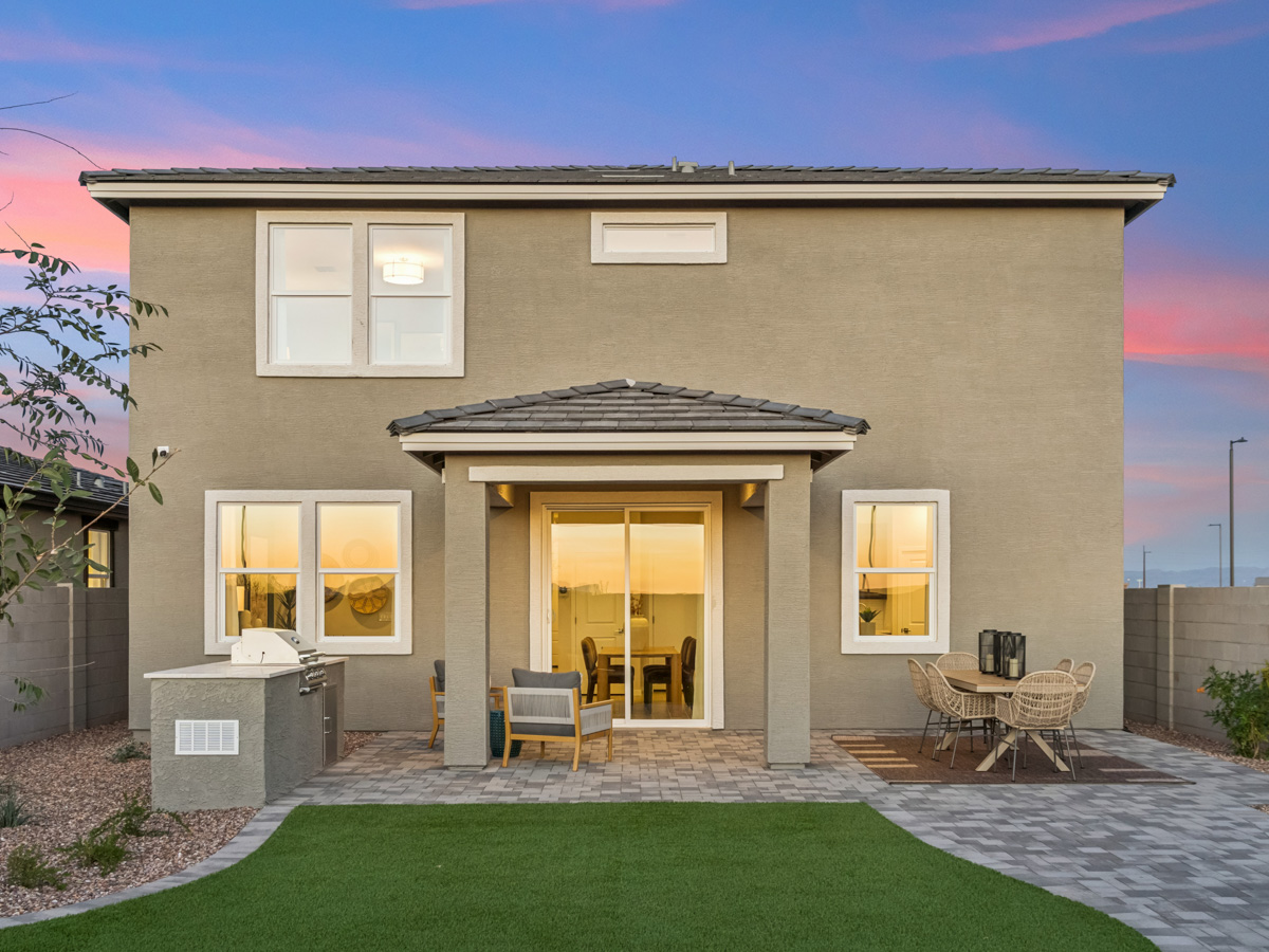 A house with a patio and a table and chairs in the front.
