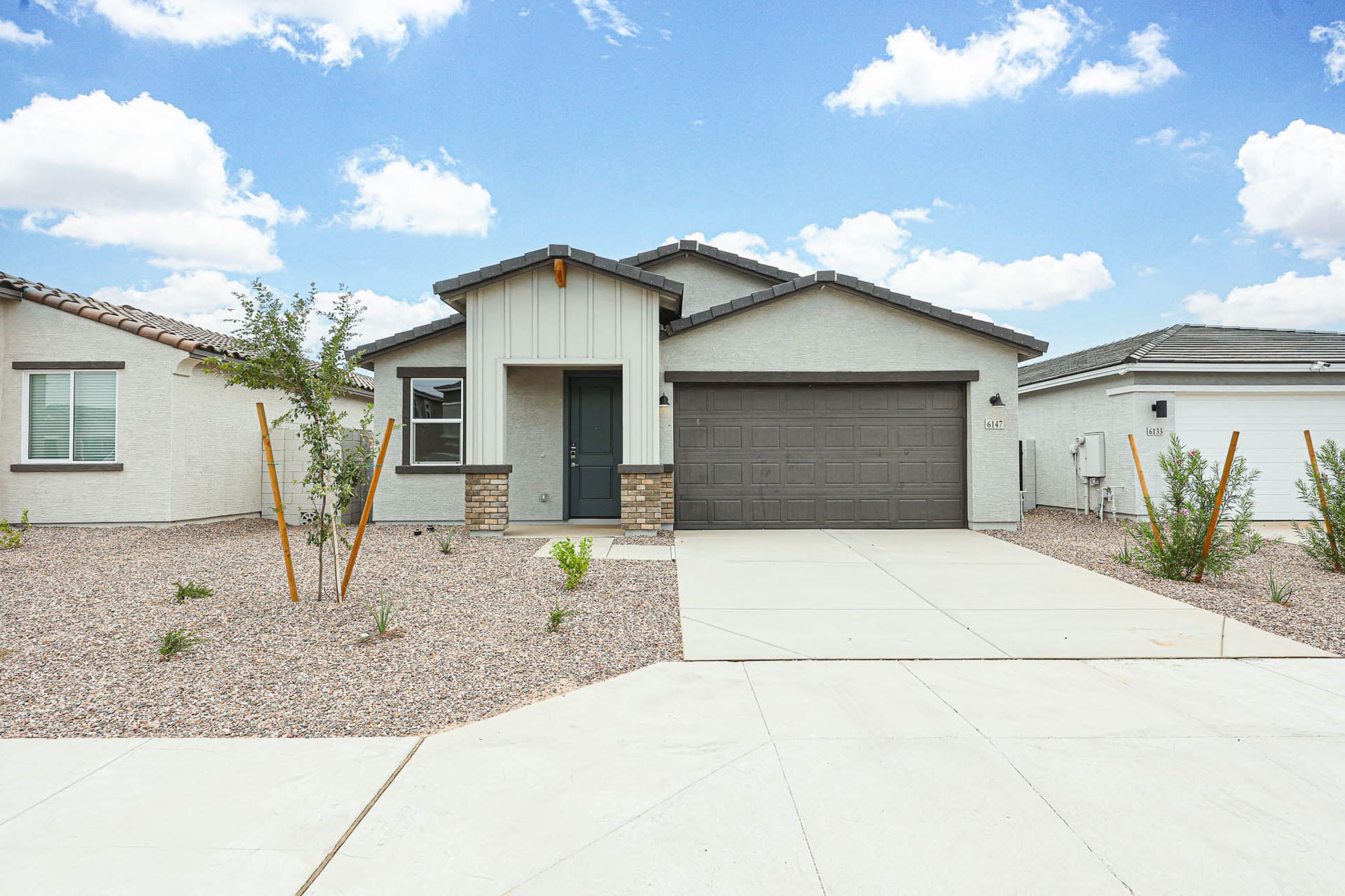 A house with garages and a tree in the front.