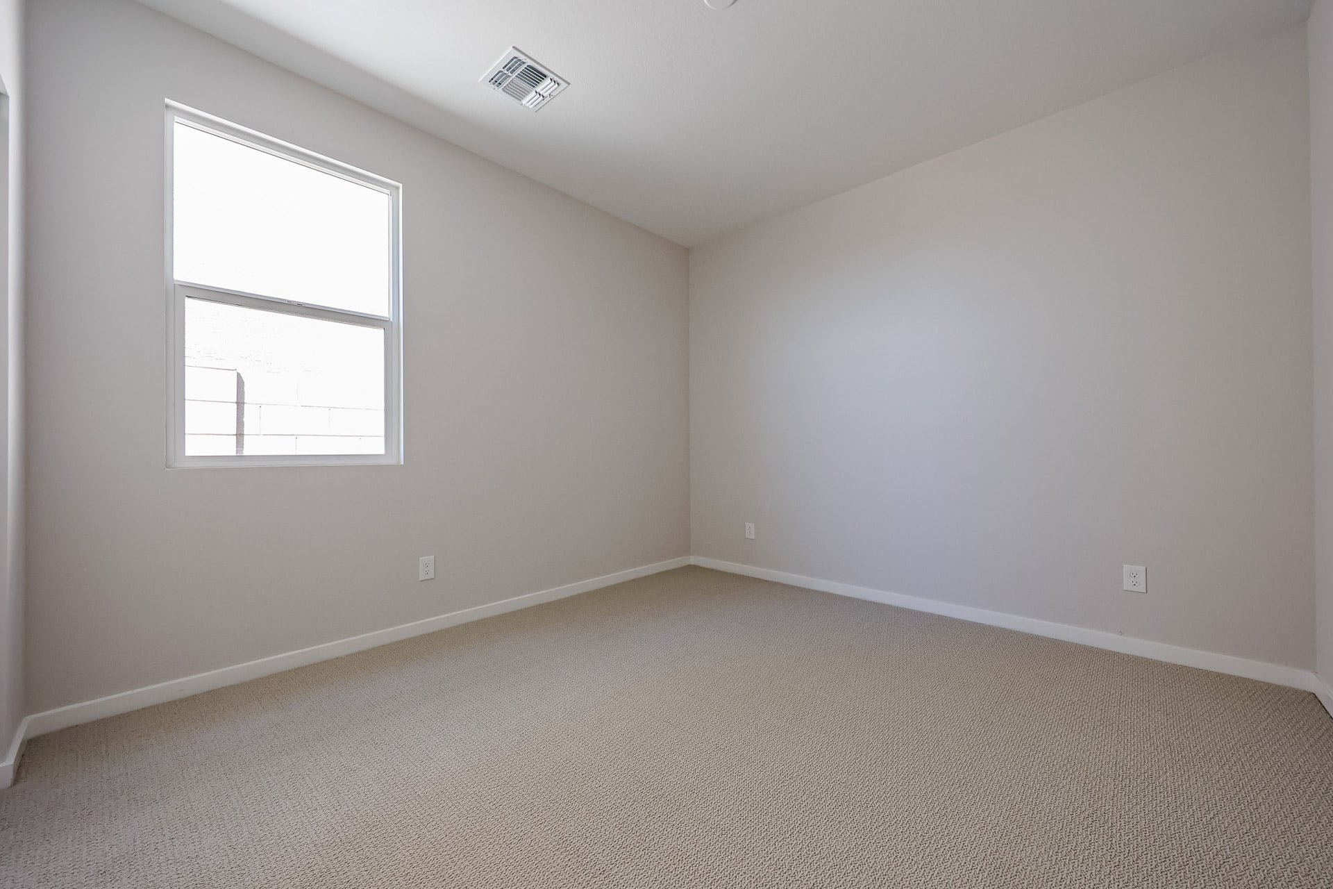 A room with a window and carpet.