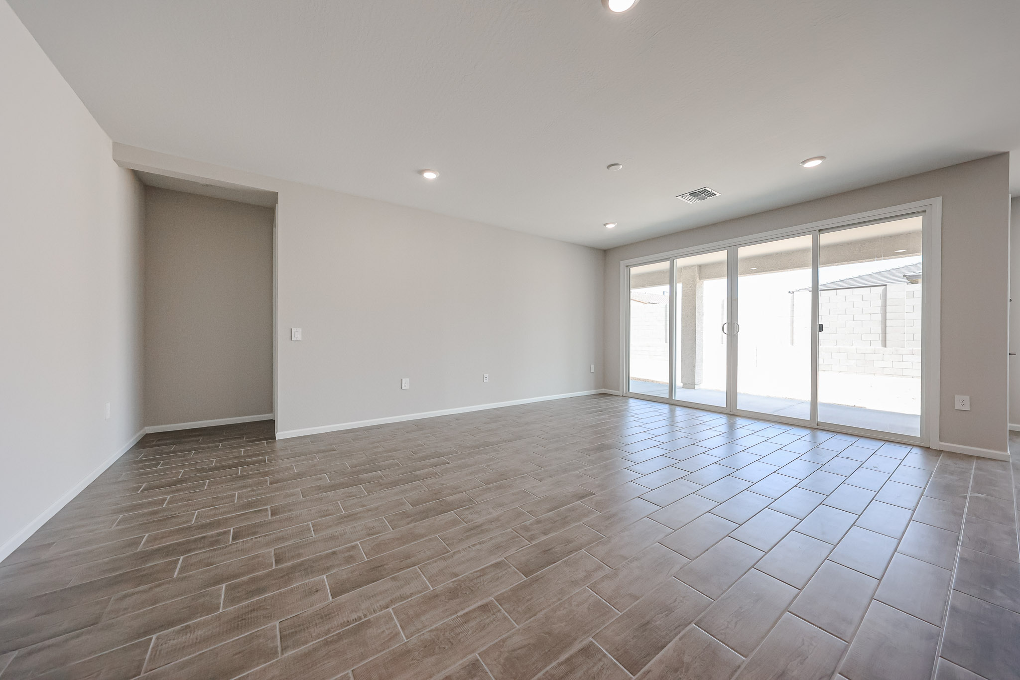 A room with a tile floor and a wood floor.