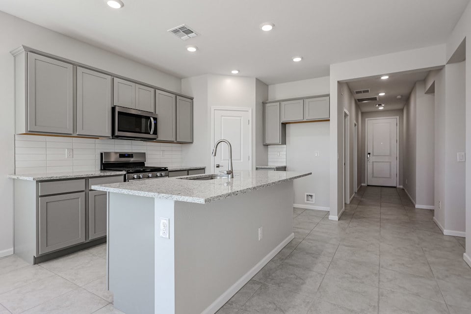 A kitchen with white cabinets.