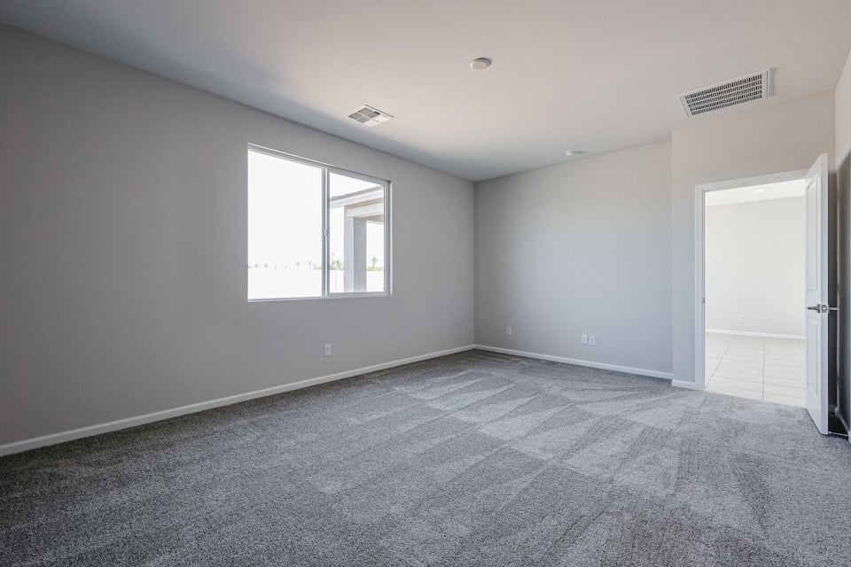 A room with a carpet and a window.