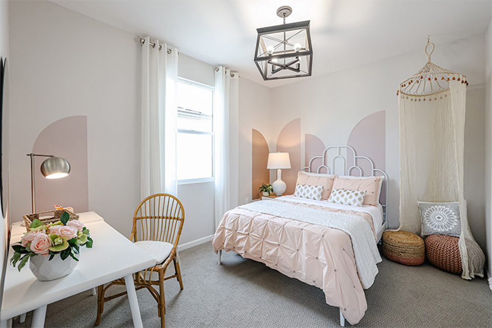 A bedroom with a bed and a table.