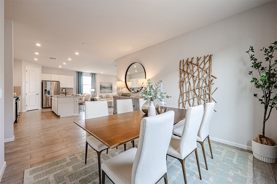 A dining room with a table and chairs.