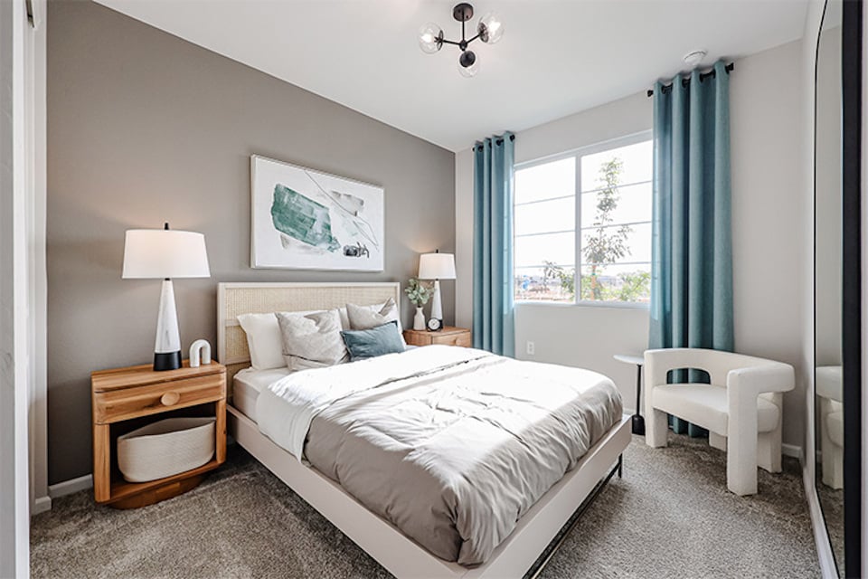 A bedroom with a bed and a chair.