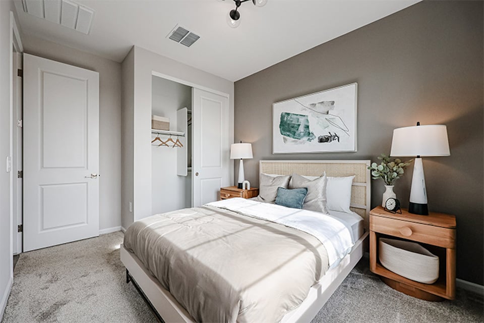 A bedroom with a bed and lamps.