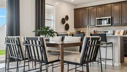 A kitchen with a table and chairs.