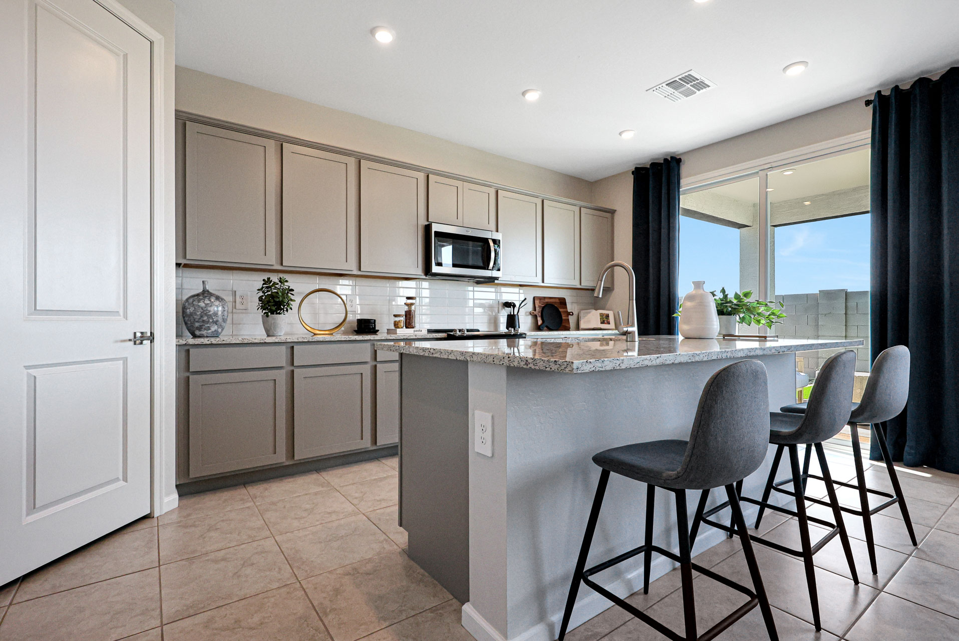 A kitchen with a sink and chairs.
