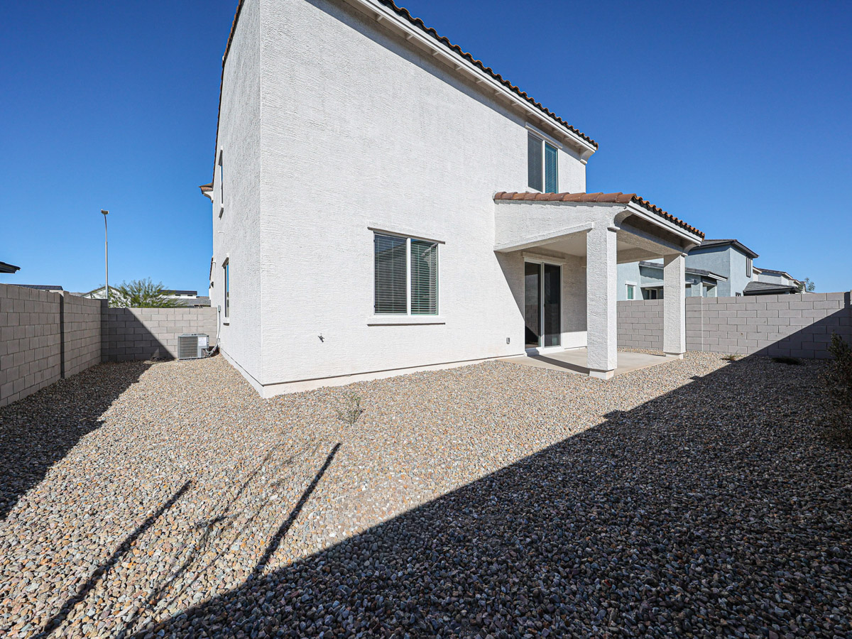 A white house with a stone driveway.