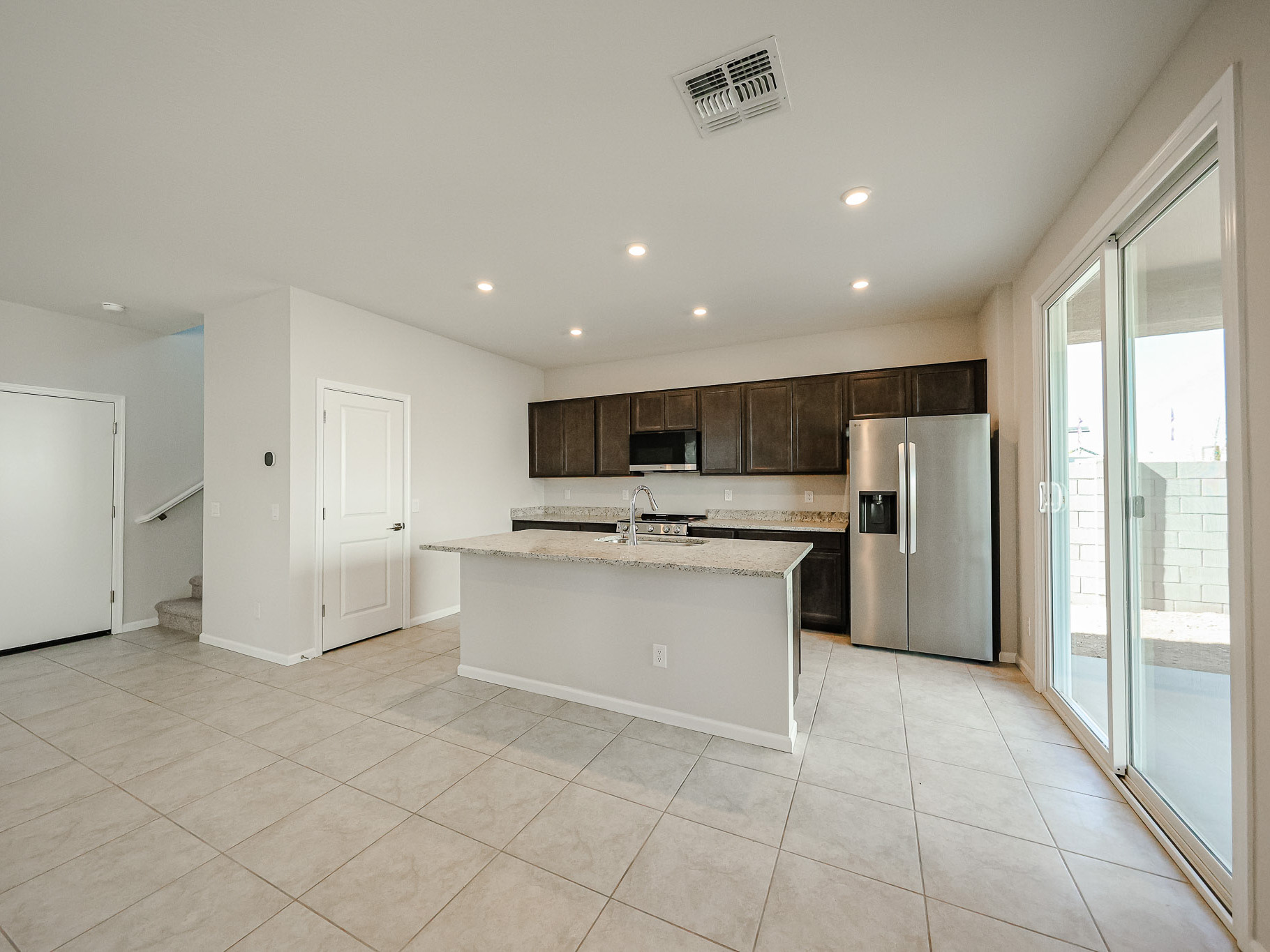 A kitchen with a large white tile floor.