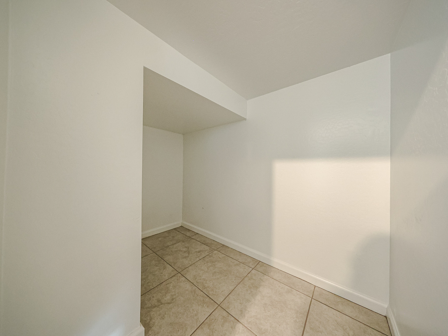 A white room with a tile floor.