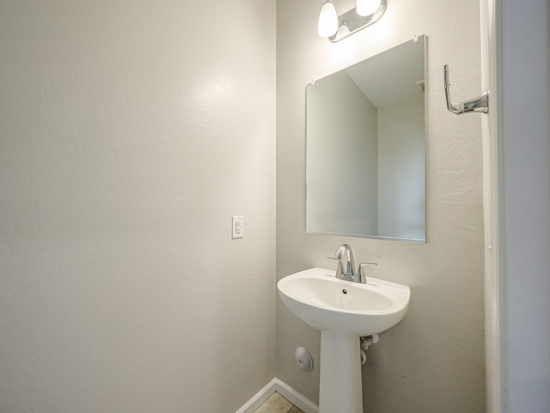 A bathroom with a mirror and sink.