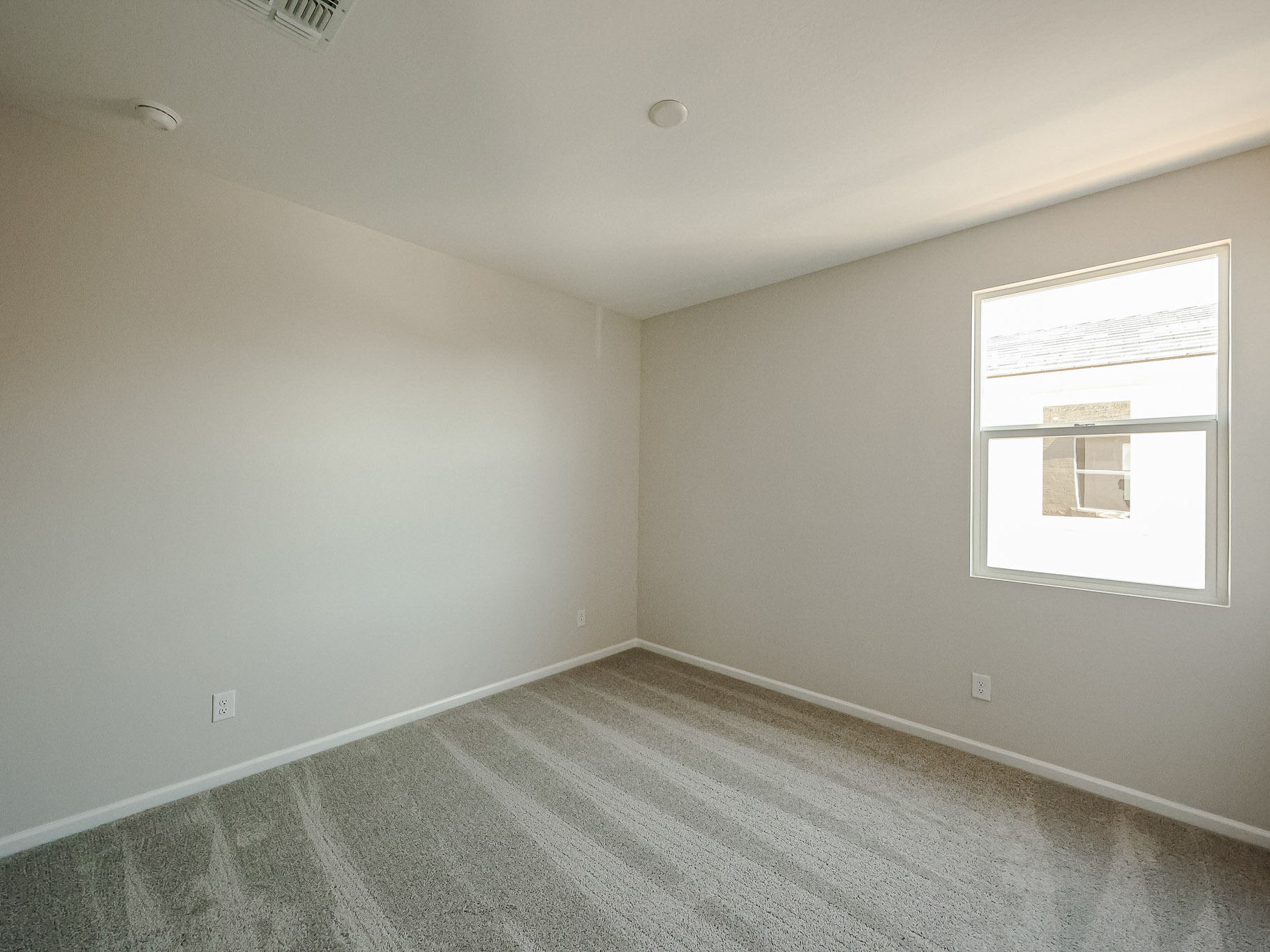 A room with a window and a carpet.