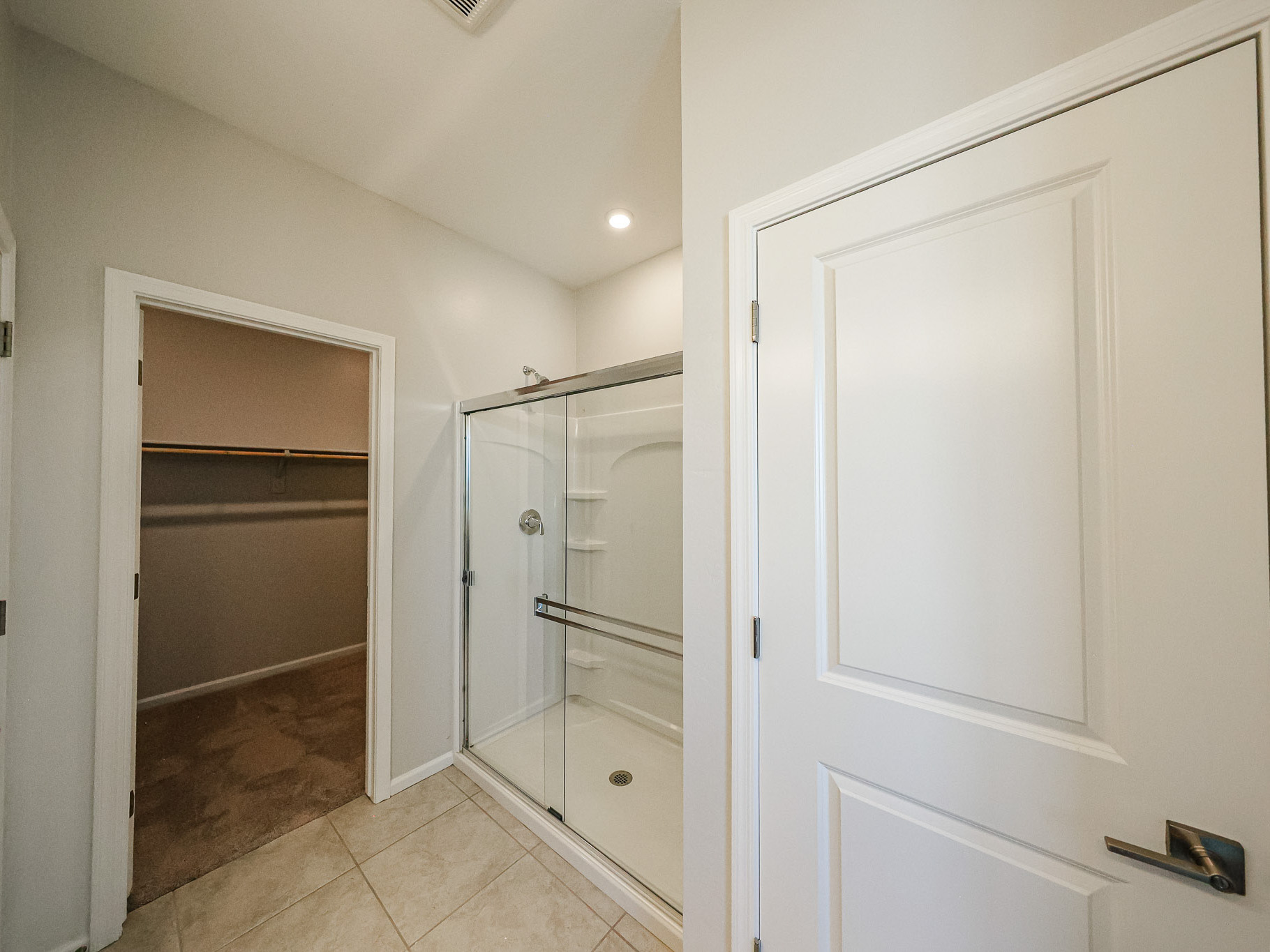 A bathroom with a shower unit and a toilet.