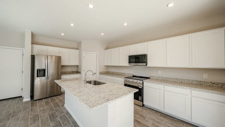 A kitchen with white cabinets.